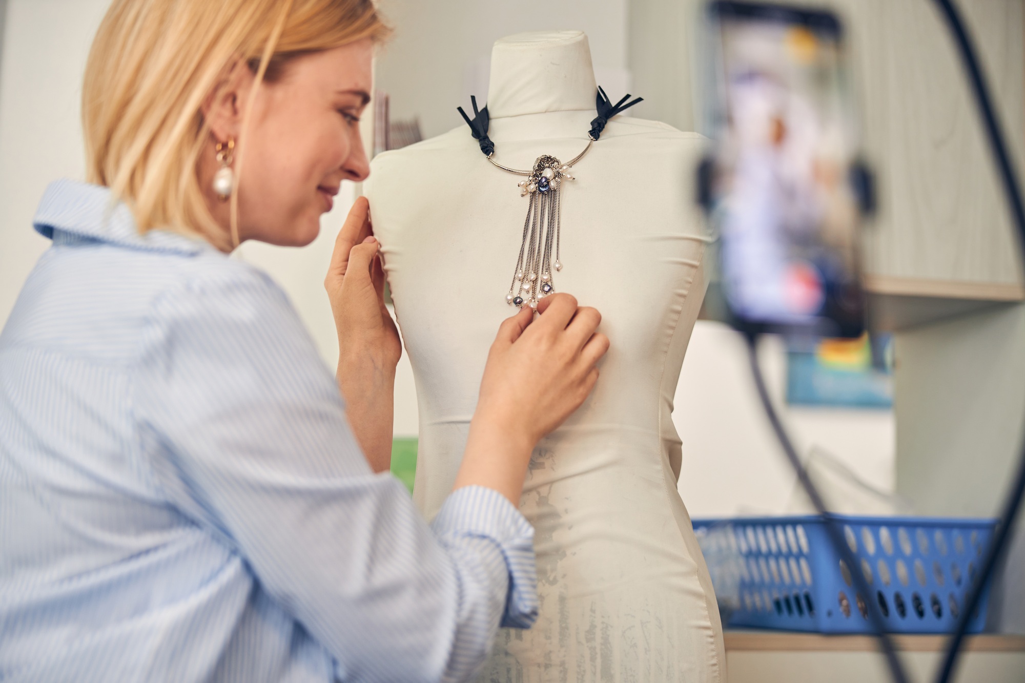 Pleased fashion blogger showing new product on dummy